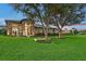 Beautiful home exterior with stone accents, lush lawn, and mature trees create curb appeal at 22343 Panther Loop, Bradenton, FL 34202