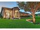 Beautiful exterior featuring a stone facade, arched entryway, lush landscaping, and an inviting walkway at 22343 Panther Loop, Bradenton, FL 34202