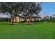 Stunning single-story home with a beautiful stone and stucco facade, mature trees, and a well-manicured lawn at 22343 Panther Loop, Bradenton, FL 34202