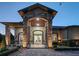 Grand front entrance featuring stone columns, an arched doorway, and meticulous landscaping at 22343 Panther Loop, Bradenton, FL 34202