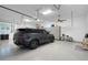 Spacious garage featuring ample storage, a ceiling fan, a vehicle, and a bicycle at 22343 Panther Loop, Bradenton, FL 34202