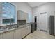 Functional laundry room with modern appliances, granite countertops, and convenient storage at 22343 Panther Loop, Bradenton, FL 34202