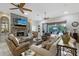 Inviting living room with a stone fireplace, plush seating, and seamless indoor-outdoor flow at 22343 Panther Loop, Bradenton, FL 34202
