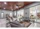 Elegant living room with wood ceiling, tile flooring, and wicker furnishings at 22343 Panther Loop, Bradenton, FL 34202
