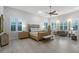 Serene main bedroom featuring neutral tones, plantation shutters, and comfortable seating area at 22343 Panther Loop, Bradenton, FL 34202