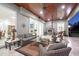 Elegant covered outdoor patio with a fireplace, stylish seating, and wood-paneled ceiling at 22343 Panther Loop, Bradenton, FL 34202