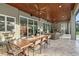Spacious outdoor patio featuring stone fireplace, dining table, and lounge area at 22343 Panther Loop, Bradenton, FL 34202