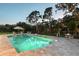 Inviting in-ground pool with lounge seating, mature trees, and a lush green lawn creating a serene backyard retreat at 22343 Panther Loop, Bradenton, FL 34202