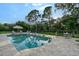 Backyard pool surrounded by lush landscaping, lounge chairs and mature trees at 22343 Panther Loop, Bradenton, FL 34202