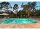 Sparkling in-ground pool with travertine tile surround, lounge chairs, and mature trees for shade and privacy at 22343 Panther Loop, Bradenton, FL 34202