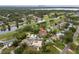 An aerial view of a property surrounded by lush green golf courses, canals, and neighboring houses with pools, showing an ideal location at 2430 Catalonia S Way, St Petersburg, FL 33712