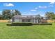 Lovely screened-in lanai and spacious backyard with healthy green lawn and manicured hedges for outdoor living and entertaining at 2430 Catalonia S Way, St Petersburg, FL 33712