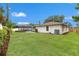 Expansive backyard with lush green grass and screened-in pool at 2430 Catalonia S Way, St Petersburg, FL 33712