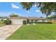 Charming single-story home featuring a manicured lawn, stone driveway, and traditional architectural details at 2430 Catalonia S Way, St Petersburg, FL 33712
