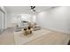 Bright living room featuring a neutral-toned couch, decorative coffee table, and modern ceiling fan at 2430 Catalonia S Way, St Petersburg, FL 33712