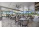 Outdoor patio seating area with pavers, ceiling fans, string lights, multiple tables, and a scenic view at 2430 Catalonia S Way, St Petersburg, FL 33712