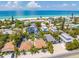Stunning aerial view of beachfront homes with private pools and lush landscaping near the ocean at 3016 Gulf Dr, Holmes Beach, FL 34217