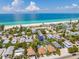 Stunning aerial view of beachfront homes near the ocean with white sand and clear blue water on a sunny day at 3016 Gulf Dr, Holmes Beach, FL 34217