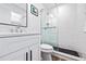 Bright bathroom with a glass shower, black pebble floor, modern vanity, and stylish fixtures at 3016 Gulf Dr, Holmes Beach, FL 34217
