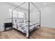 Beautiful bedroom featuring a canopy bed, wood-look floors, white shiplap accent wall and bright natural light at 3016 Gulf Dr, Holmes Beach, FL 34217