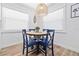 Cozy dining area with a round wood table, four blue chairs, and a rattan pendant light fixture at 3016 Gulf Dr, Holmes Beach, FL 34217