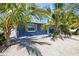 Charming blue exterior with gravel yard and tropical plants providing shade at 3016 Gulf Dr, Holmes Beach, FL 34217