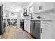 Contemporary kitchen with white cabinets, stainless steel appliances, marble backsplash and wood-look floors at 3016 Gulf Dr, Holmes Beach, FL 34217