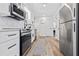 Modern kitchen with stainless steel appliances, white cabinets, marble countertops, and wood-look flooring at 3016 Gulf Dr, Holmes Beach, FL 34217