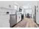 Modern kitchen features white cabinets, stainless steel appliances, and a cozy dining area at 3016 Gulf Dr, Holmes Beach, FL 34217