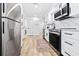 Bright white kitchen with stainless steel appliances, marble backsplash, and modern hardware at 3016 Gulf Dr, Holmes Beach, FL 34217