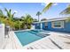 Beautiful pool and spa surrounded by palm trees and white tile, perfect for relaxation at 3016 Gulf Dr, Holmes Beach, FL 34217