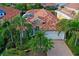 Stunning aerial view of a tile roof home with lush landscaping, pool and a paved driveway at 303 9Th E Ave, Palmetto, FL 34221