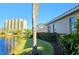 Picturesque view of backyard with lake access, lush landscaping, and a glimpse of community amenities at 303 9Th E Ave, Palmetto, FL 34221
