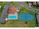 Birds eye view of a community pool and tennis court surrounded by manicured landscaping and lush green space at 303 9Th E Ave, Palmetto, FL 34221