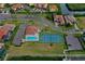 Aerial view of a community pool and tennis court surrounded by well-manicured landscaping and red-tiled roof buildings at 303 9Th E Ave, Palmetto, FL 34221