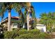 Attractive home exterior with lush landscaping, mature palm trees, a tile roof, and attached two car garage at 303 9Th E Ave, Palmetto, FL 34221