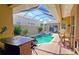 Enclosed backyard pool with a spa, outdoor kitchen, and a seating area at 303 9Th E Ave, Palmetto, FL 34221