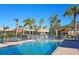 Community pool with lounge chairs and palm trees, perfect for relaxing and enjoying the sunshine at 303 9Th E Ave, Palmetto, FL 34221