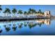 Picturesque waterfront view showcasing a marina with boats, palm trees, and a Mediterranean-style building at 303 9Th E Ave, Palmetto, FL 34221