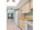 Modern kitchen showcasing white appliances with seamless flow into the light-filled living area at 3072 Lake Bayshore Dr # 119, Bradenton, FL 34205