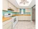 Well-lit kitchen featuring white appliances, ample cabinetry and a skylight at 3072 Lake Bayshore Dr # 119, Bradenton, FL 34205