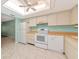 Bright kitchen featuring white appliances, ceiling fan, and tile flooring for easy maintenance at 3072 Lake Bayshore Dr # 119, Bradenton, FL 34205