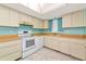 Functional kitchen featuring modern appliances, a window with custom curtains, and tile flooring at 3072 Lake Bayshore Dr # 119, Bradenton, FL 34205