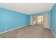 Bright living room includes lanai access and neutral gray carpet at 3072 Lake Bayshore Dr # 119, Bradenton, FL 34205