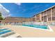 Relaxing pool area with lounge chairs, umbrellas, and a view of the buildings at 3072 Lake Bayshore Dr # 119, Bradenton, FL 34205