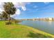 Beautiful lakefront view showcasing lush green grass and tropical foliage at 3072 Lake Bayshore Dr # 119, Bradenton, FL 34205
