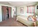 Bedroom with closet, twin bed, curtains, and Dunedin art adding character to this cozy space at 3402 Shingle Oak Ter, Sarasota, FL 34237