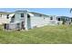 Side exterior view of the manufactured home featuring green siding and awnings over the windows at 3402 Shingle Oak Ter, Sarasota, FL 34237
