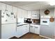 Well-lit kitchen featuring white cabinets, appliances, and wood-look flooring for a clean and inviting cooking space at 3402 Shingle Oak Ter, Sarasota, FL 34237
