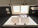 Close-up of kitchen sink showcasing its design, surrounded by light and ample countertop space and under-cabinet lighting at 3402 Shingle Oak Ter, Sarasota, FL 34237